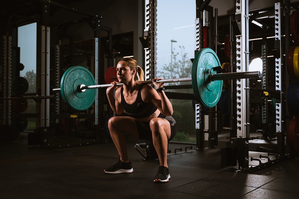 Strong women Yasmine squatting with a barbell